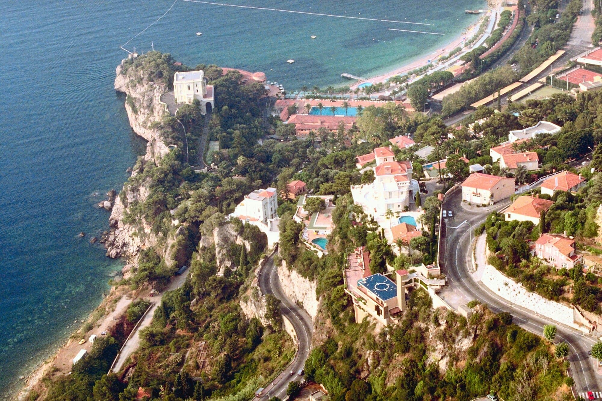 Aerial of the Cap-Martin coast — the cliffside Riviera geography Hitchcock used as the visual register of the Robie villa scenes.
